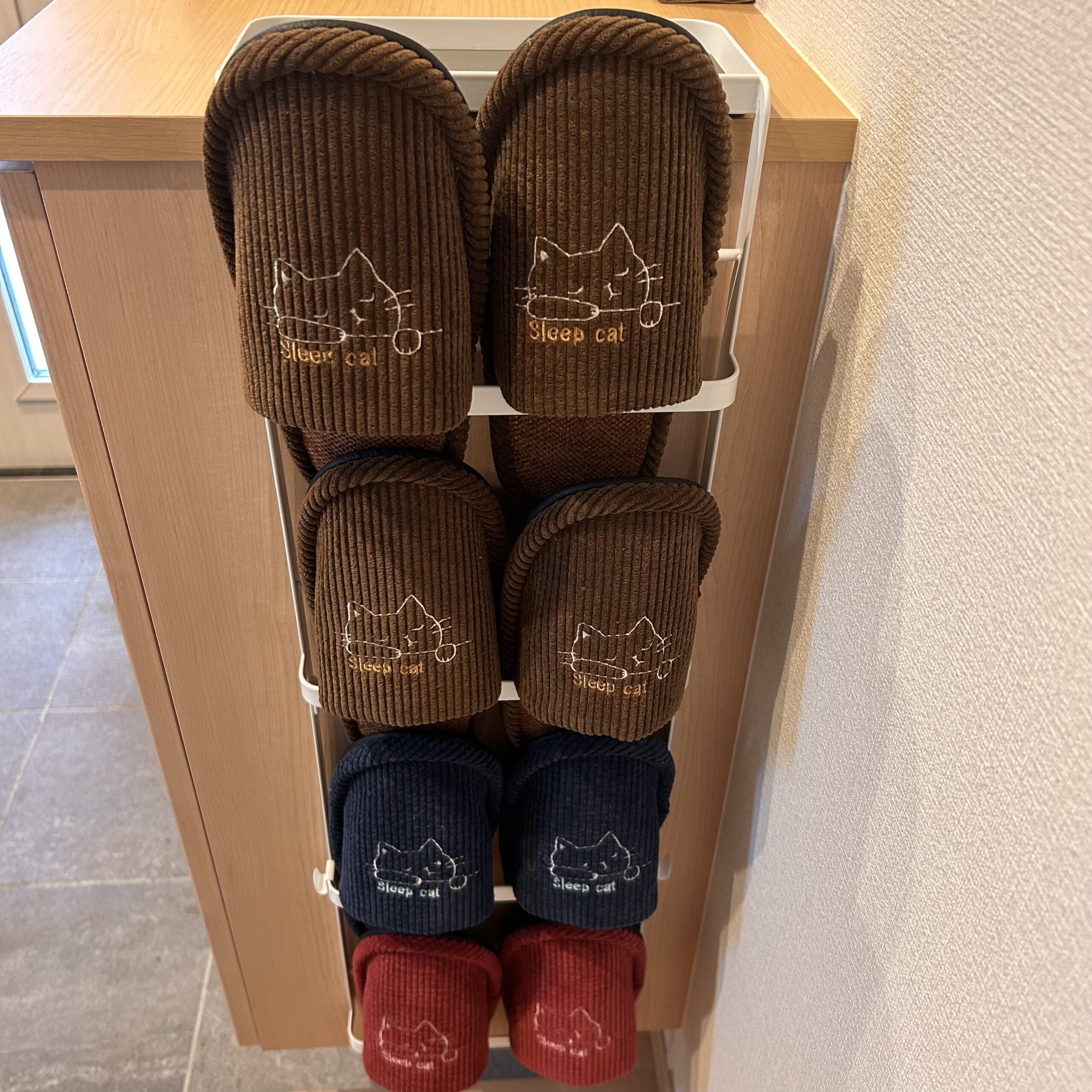 玄関で山崎実業towerの引っ掛け式スリッパラックにスリッパを掛けて収納している様子（本来の使い方）