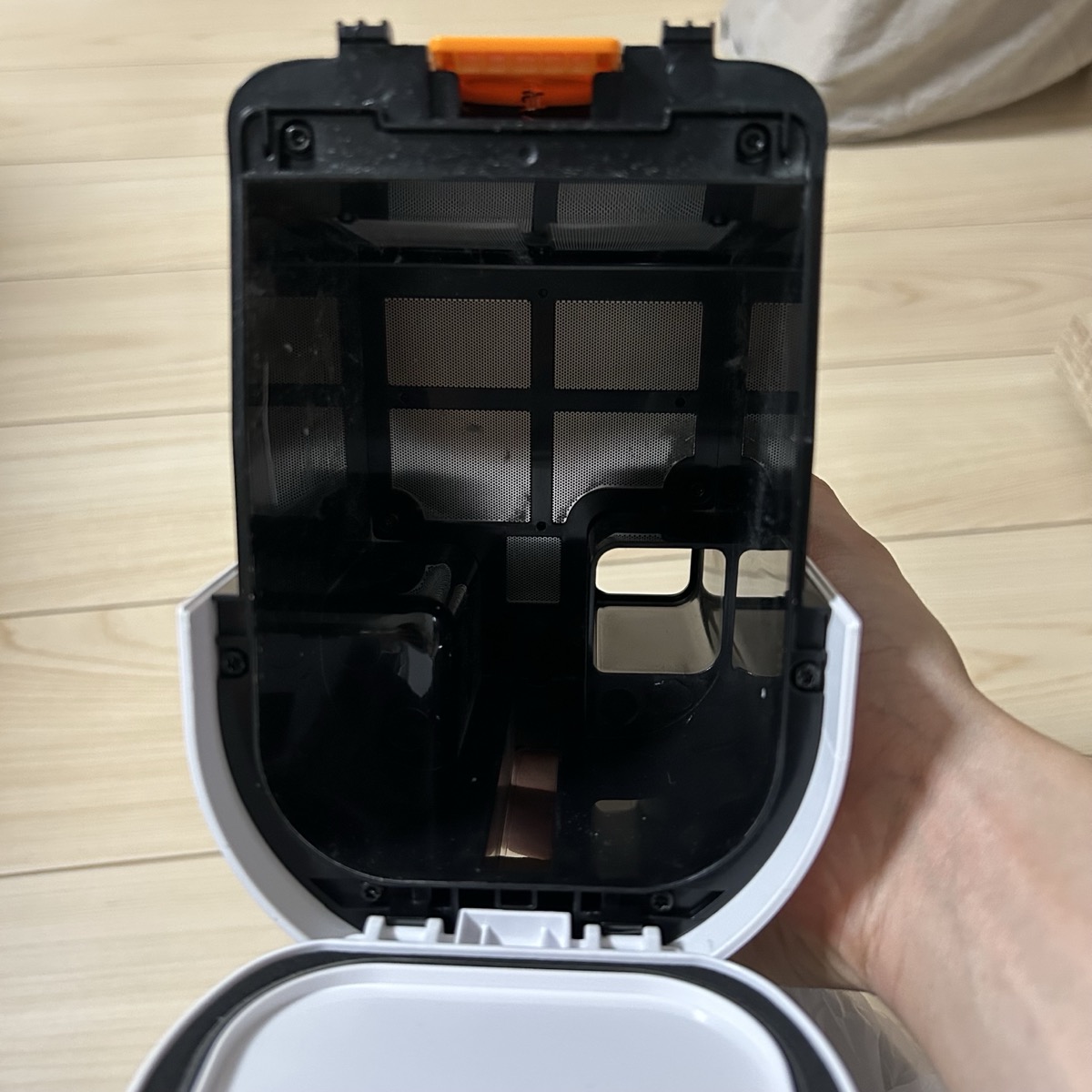 シャークLC150JBLの自動ごみ収集ドックを開けたところ。オレンジのタブをワンタップでゴミを捨てられる