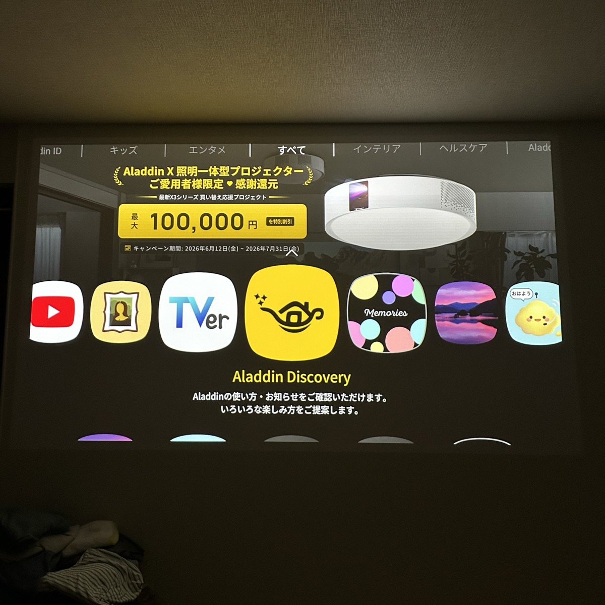 ポップインアラジン2で寝室の壁に投影したホーム画面。YouTubeやTVerなどのアプリが並ぶ